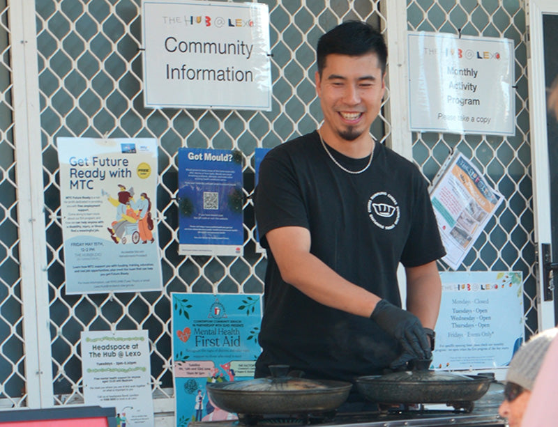 Jason serves dumplings at the community hub